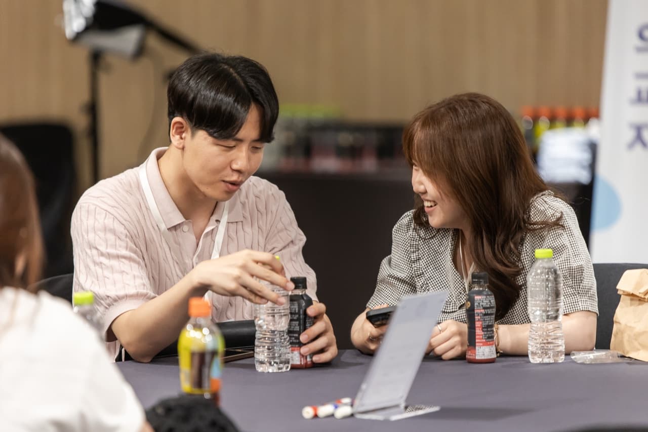 IPE 팀별 활동 중 두 학생이 원형 테이블에서 대화를 나누며 웃고 있는 모습