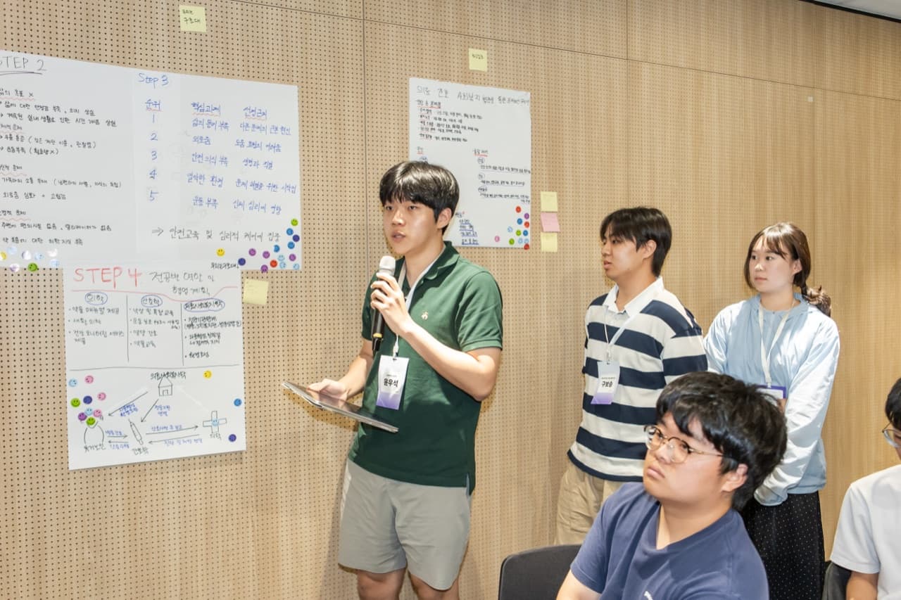 대학교 학생들이 포스터 전시를 둘러보는 모습