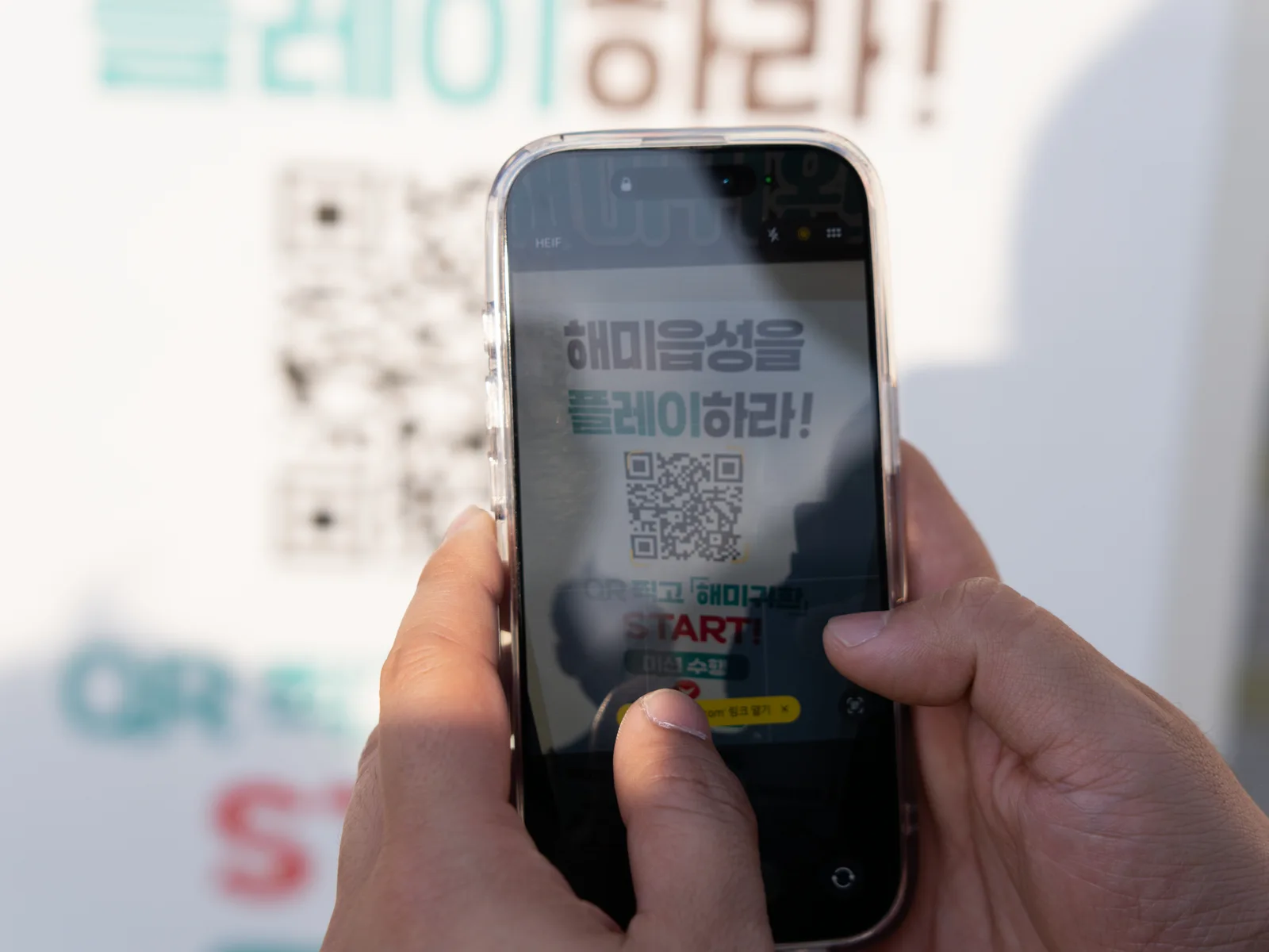 QR 안내판을 향해 휴대전화를 든 모습