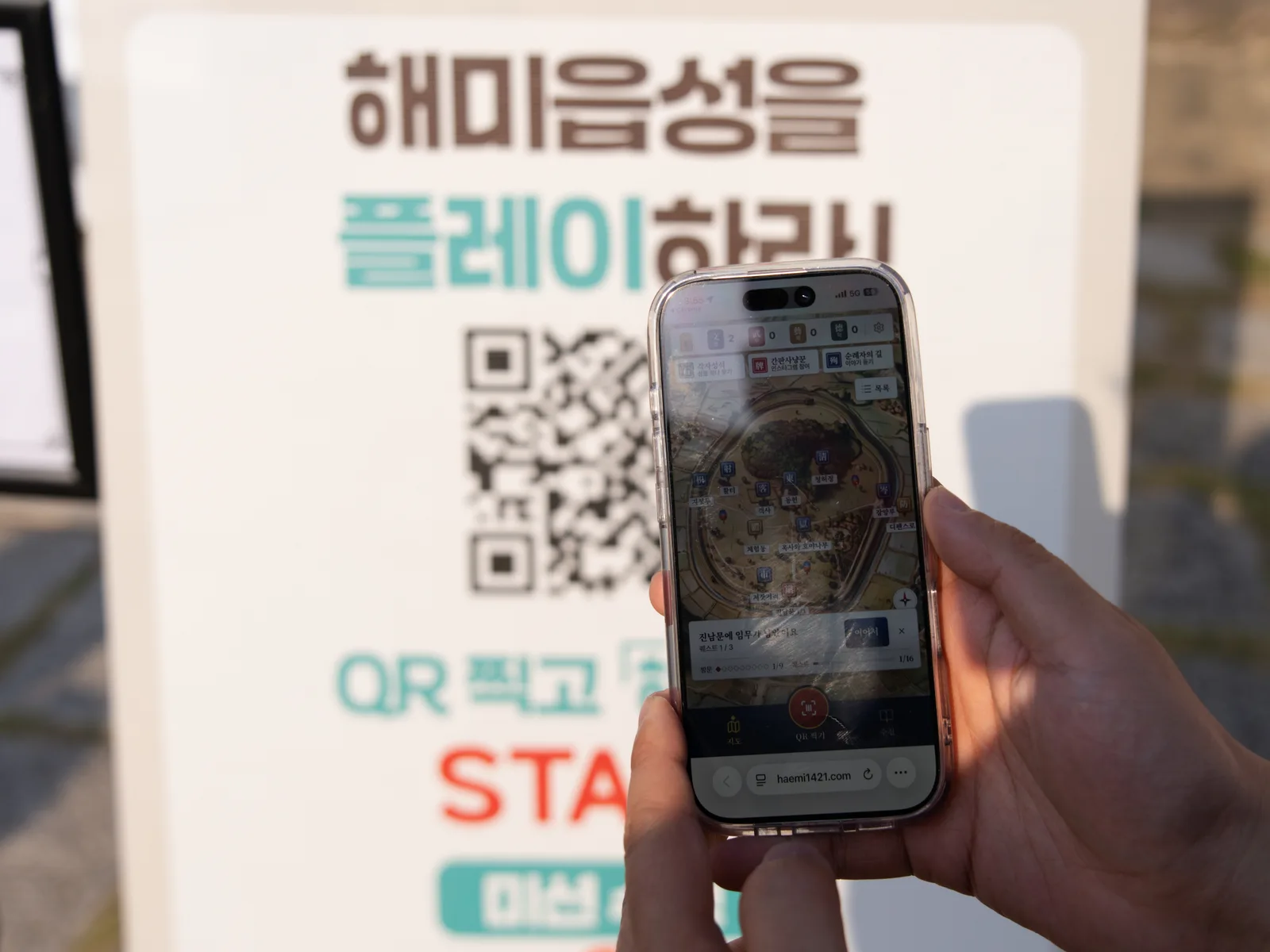 안내 배너 앞 휴대전화에 표시된 게임 지도