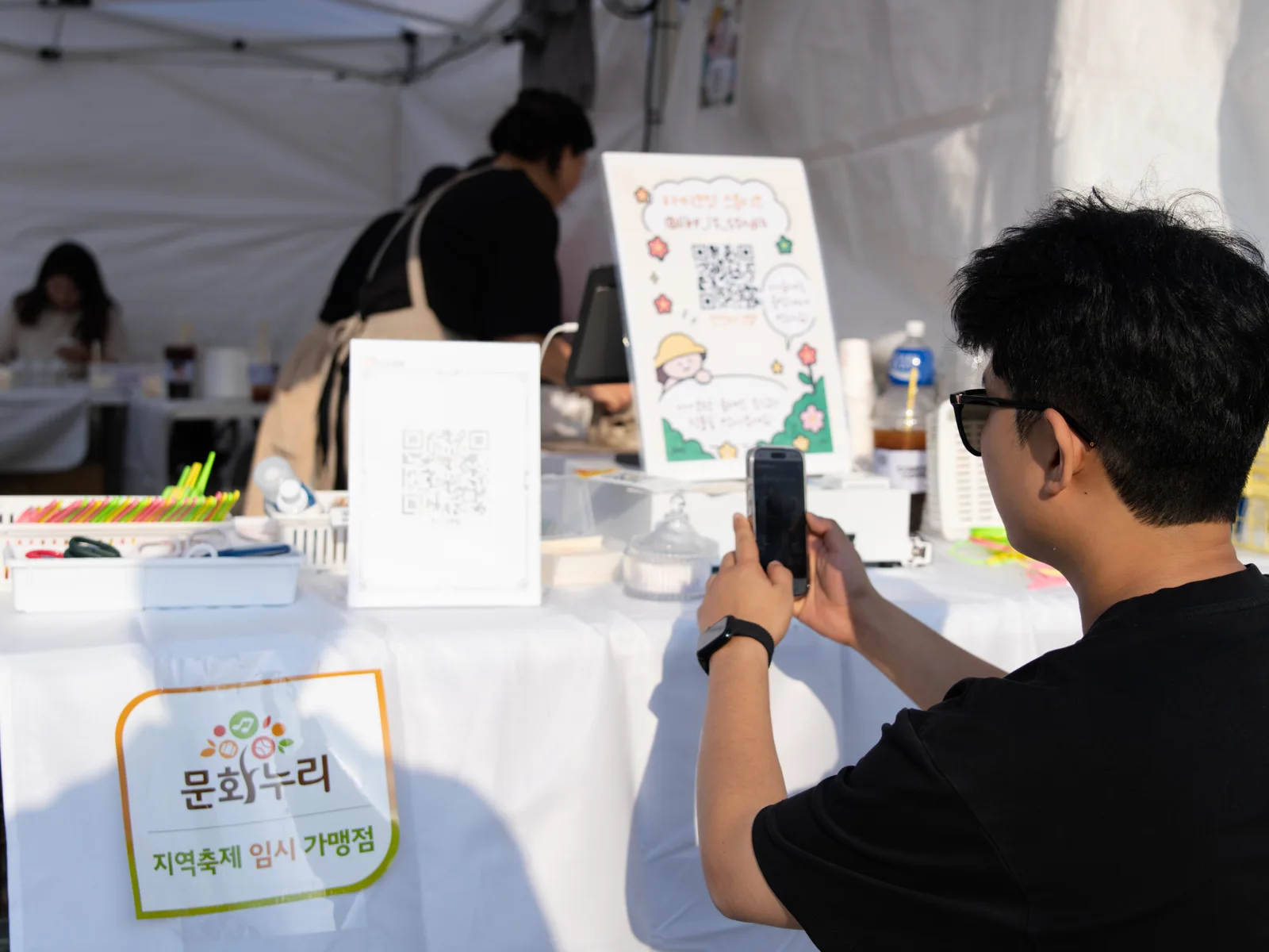체험 부스 QR 표지 앞에서 휴대전화를 든 모습