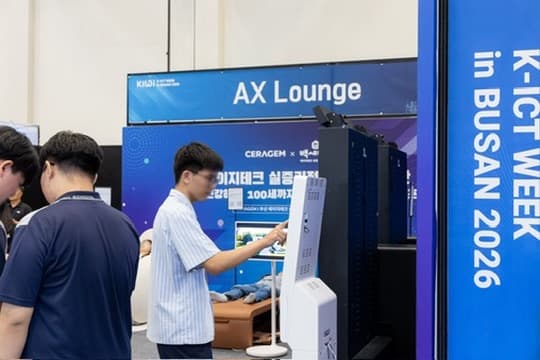 A visitor touching the screen of a white kiosk in the AX Lounge