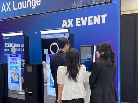 Visitors using equipment beneath the AX EVENT sign