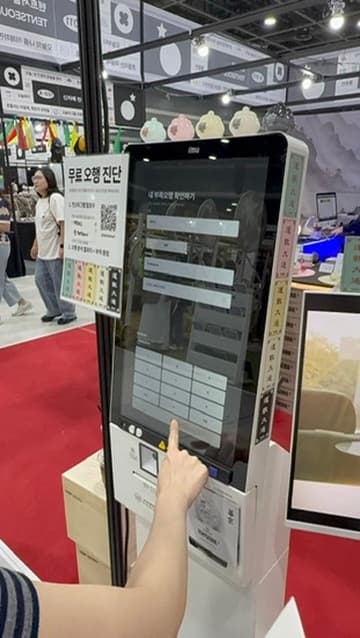 관람객이 부스 키오스크 화면을 직접 터치하는 모습