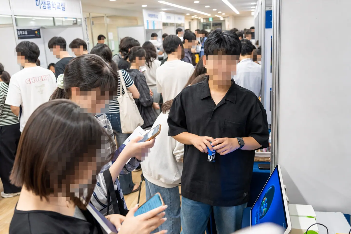 연세의대 진로선택박람회 방문객이 사업단 부스의 디지털 체험 화면 앞에 모인 장면
