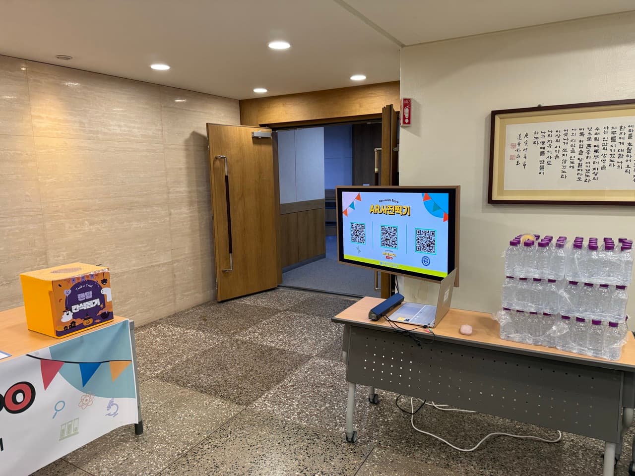 행사장 입구 안내 데스크와 등록을 기다리는 참석자들