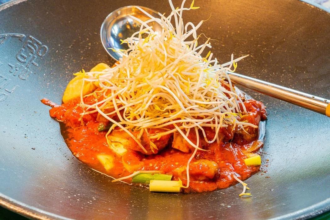 Chicken and vegetables served on a large pot lid