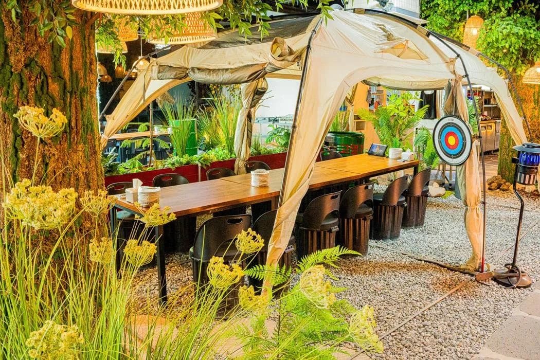 Group dining table and chairs beneath an indoor tent at Camping Gorae Dining