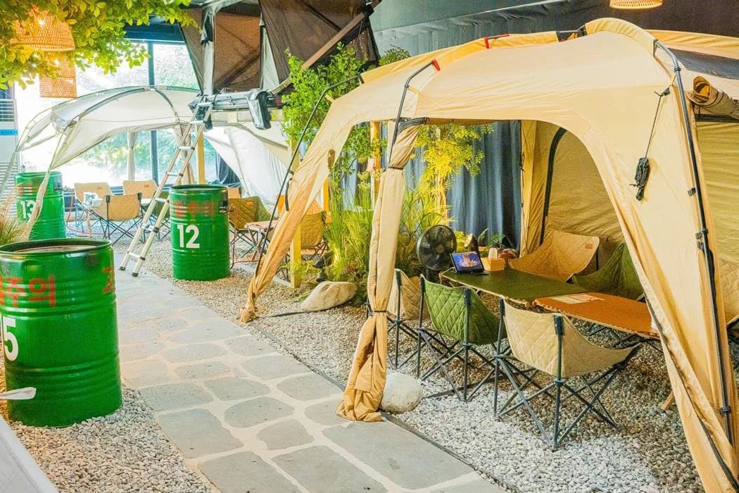 Indoor tent seating decorated with camping items and plants