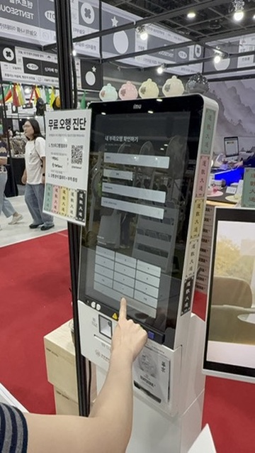 관람객이 무료 오행 진단 키오스크 화면을 직접 터치하는 모습